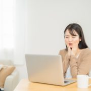 パソコンの前で悩む女性