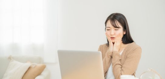 パソコンの前で悩む女性