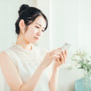 スマホを見て悩む女性